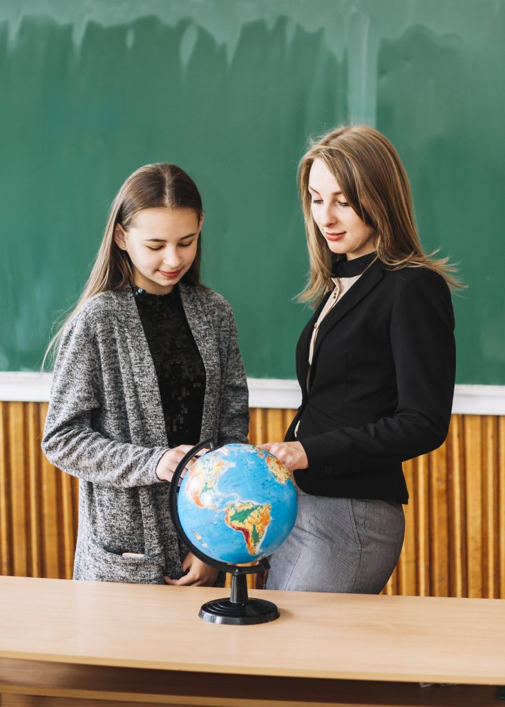 student-girl-learning-geography-with-female-teacher